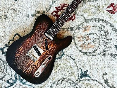 The guitar has brown color on the edges with some designs in the middle.